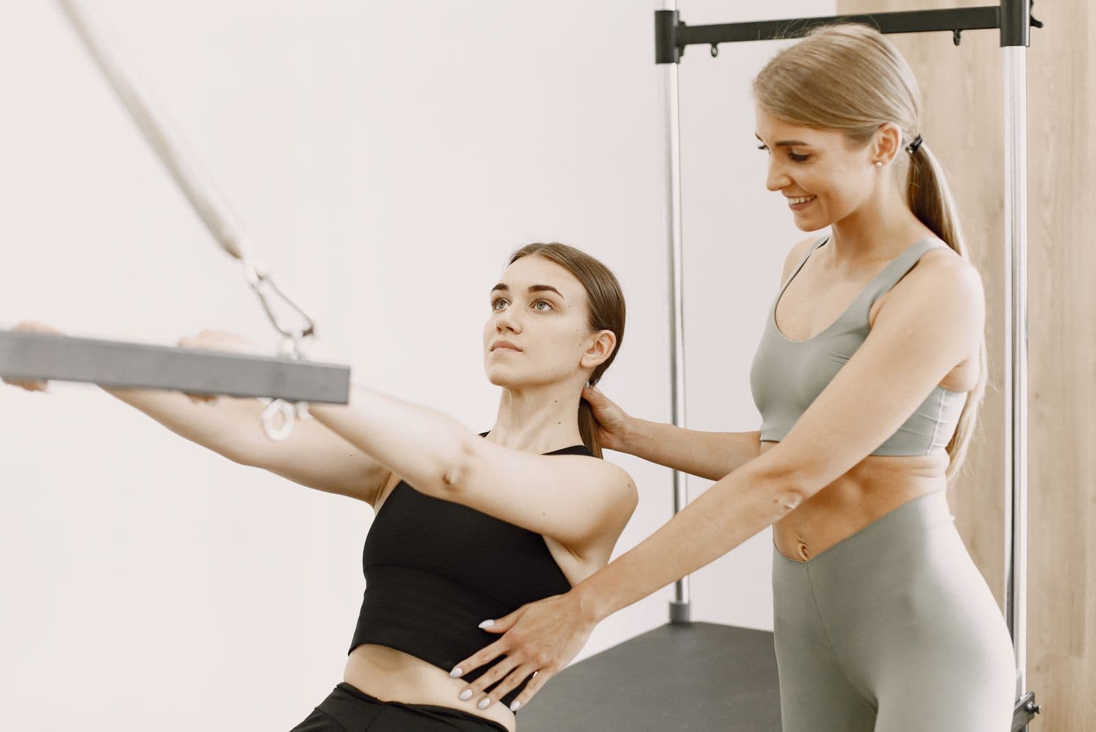 Illustrative personal trainer guiding a cable exercise