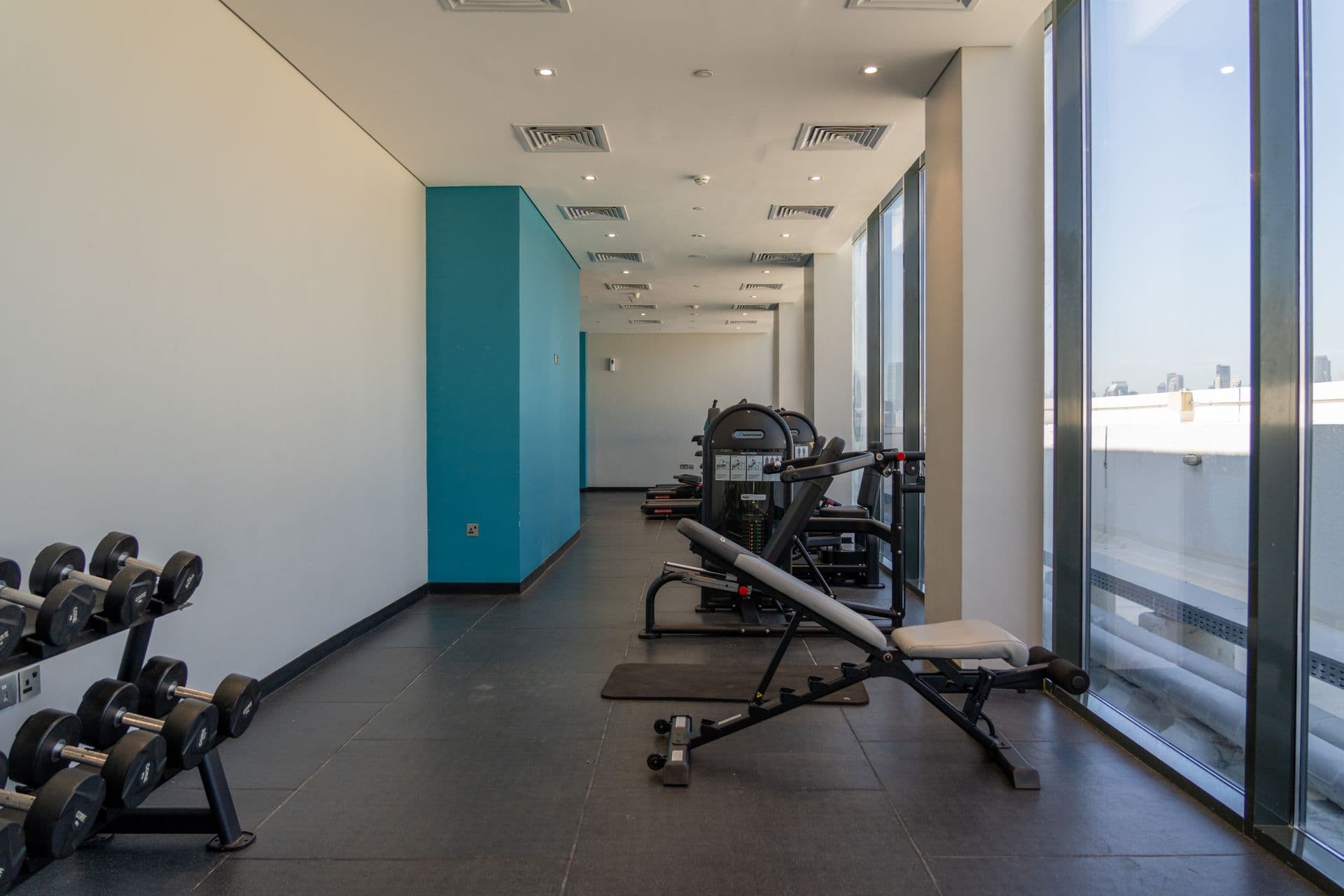 Illustrative gym interior with weight benches and equipment